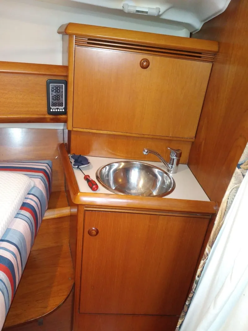 Slide: The Image of Interior of Jeanneau Sun Odyssey 40.3, 2005, featuring sink and wooden cabinets. - 16