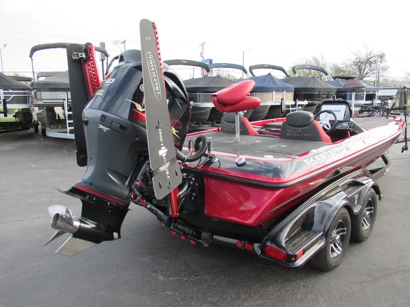Slide: The Image of 2016 Skeeter FX 21 bass boat with powerful outboard motor, red and black design. - 5