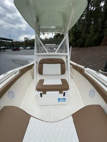 Slide: The Image of 2024 Pioneer Sportfish 202 boat interior with cushioned seating and white deck. - 11