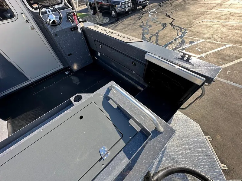 Slide: The Image of 2024 Duckworth 26 Offshore boat interior with storage compartments and steering wheel. - 10
