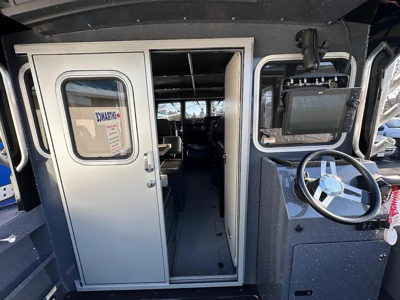 Slide: The Image of 2024 Duckworth 26 Offshore boat interior with steering wheel and navigation equipment. - 26