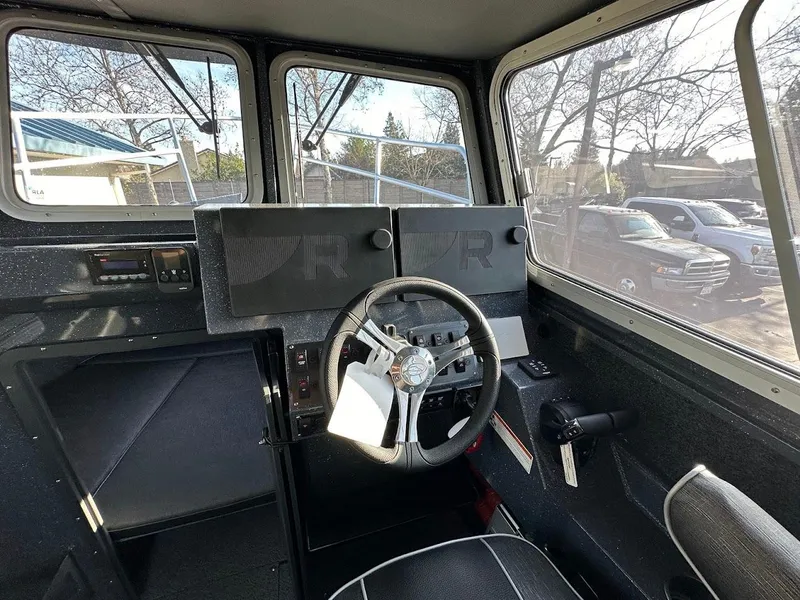 Slide: The Image of 2024 Duckworth 26 Offshore boat interior with steering wheel and dashboard controls. - 33