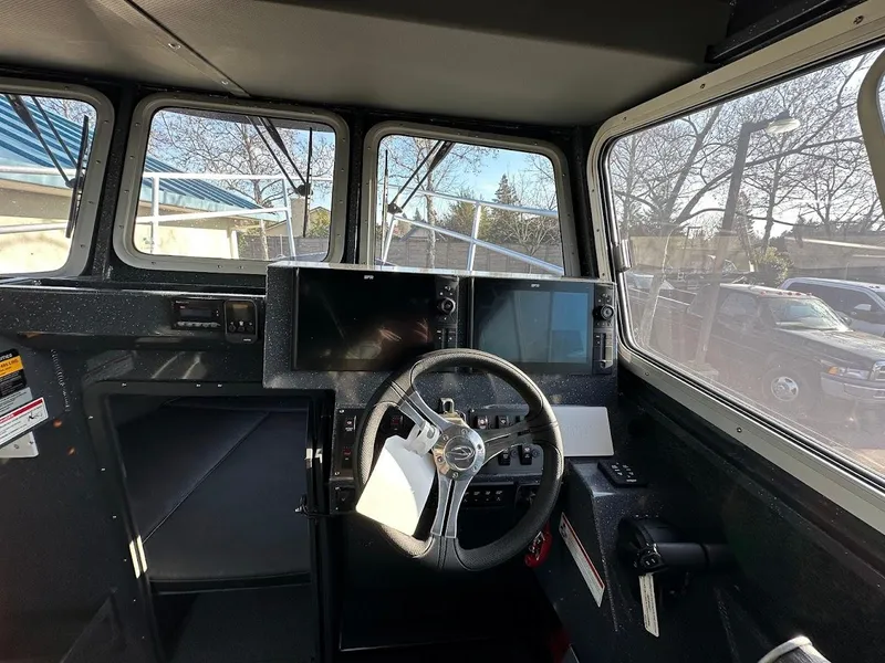 Slide: The Image of 2024 Duckworth 26 Offshore boat cockpit with steering wheel and navigation screens. - 34