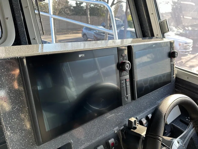 Slide: The Image of 2024 Duckworth 26 Offshore boat dashboard with dual navigation screens and steering wheel. - 35