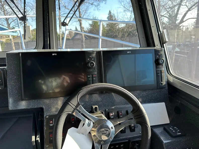Slide: The Image of 2024 Duckworth 26 Offshore boat cockpit with dual navigation screens and steering wheel. - 36