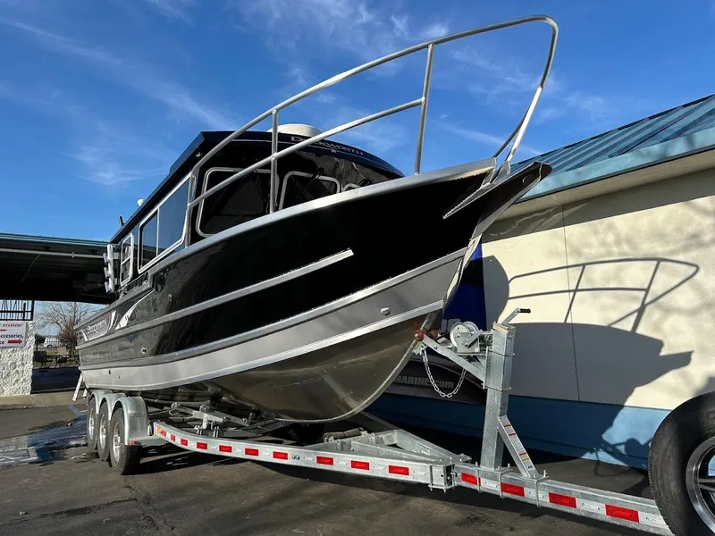 Slide: The Image of 2024 Duckworth 26 Offshore boat on trailer, sleek black design, parked outdoors. - 5