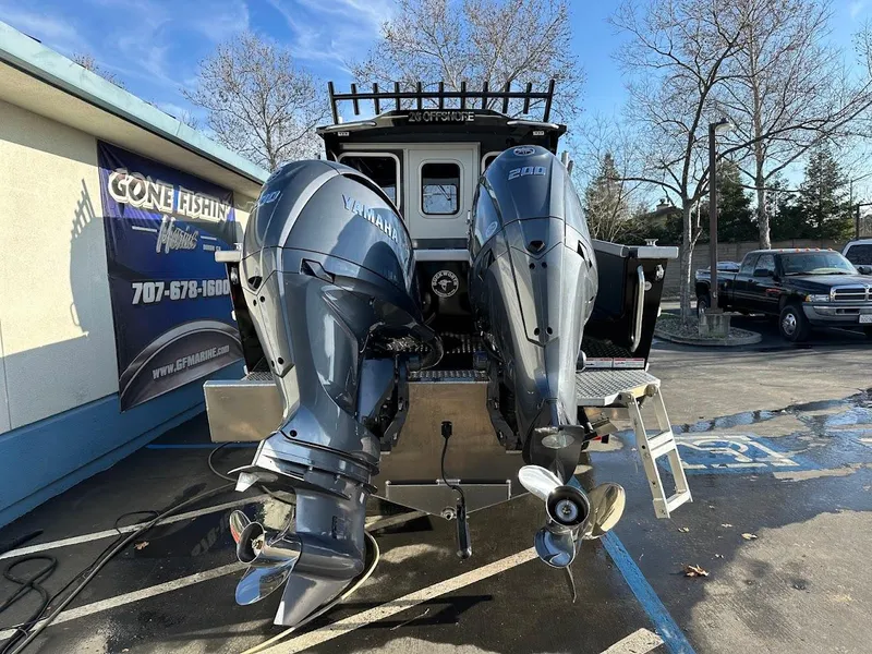Slide: The Image of 2024 Duckworth 26 Offshore boat with dual outboard motors in a parking lot. - 9