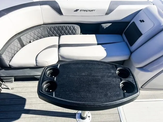 Slide: The Image of 2024 Starcraft CX 23 FD boat interior with seating and cupholder table. - 12