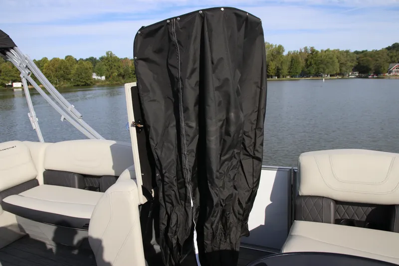 Slide: The Image of 2024 Starcraft CX 23 FD pontoon boat interior with black cover and lake view. - 16