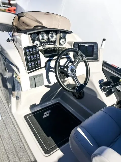 Slide: The Image of 2024 Starcraft CX 23 FD boat dashboard with steering wheel and control panel. - 3