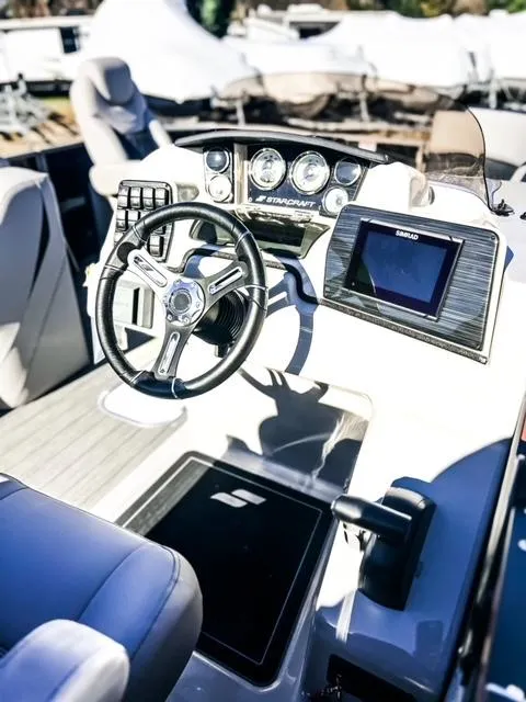 Slide: The Image of 2024 Starcraft CX 23 FD boat dashboard with steering wheel and navigation system. - 4