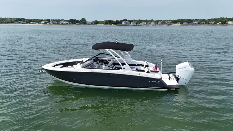 Slide: The Image of 2024 Cobalt R8 Outboard boat on calm water with distant shoreline. - 1