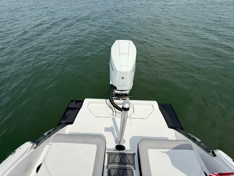 Slide: The Image of 2024 Cobalt R8 Outboard boat on water, rear view with engine visible. - 10