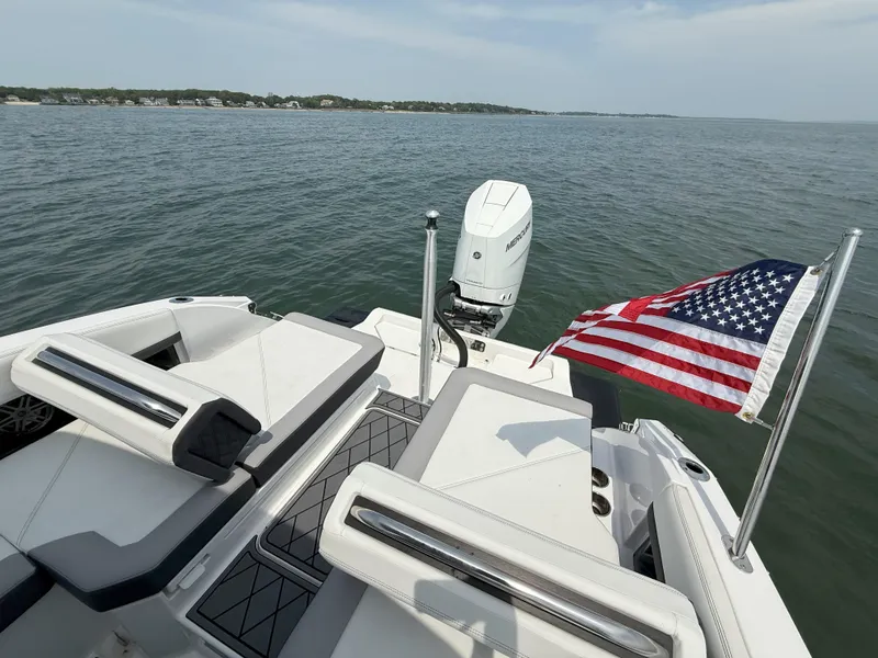 Slide: The Image of 2024 Cobalt R8 Outboard boat with American flag on open water. - 11