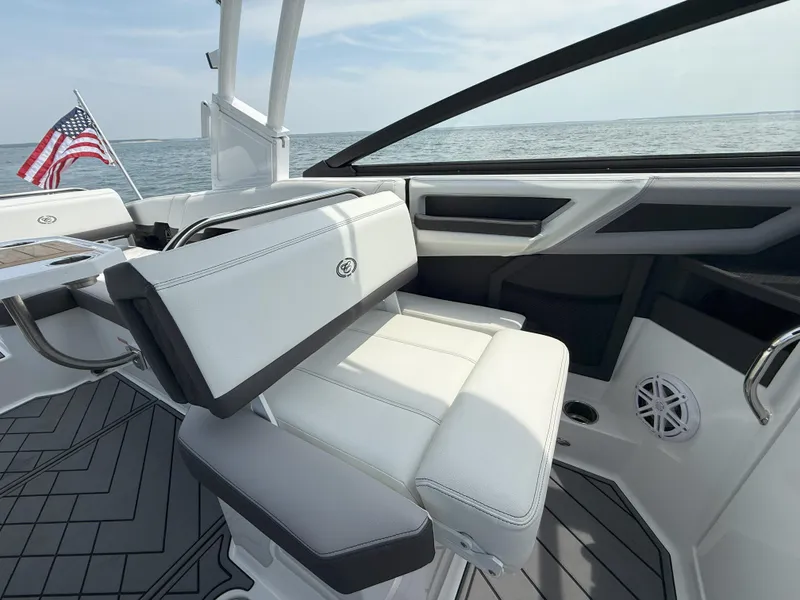 Slide: The Image of 2024 Cobalt R8 Outboard boat interior with white seating and American flag. - 16