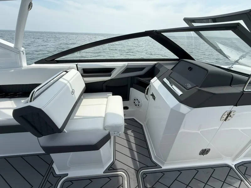 Slide: The Image of 2024 Cobalt R8 Outboard boat interior with sleek seating and modern dashboard, overlooking the ocean. - 17