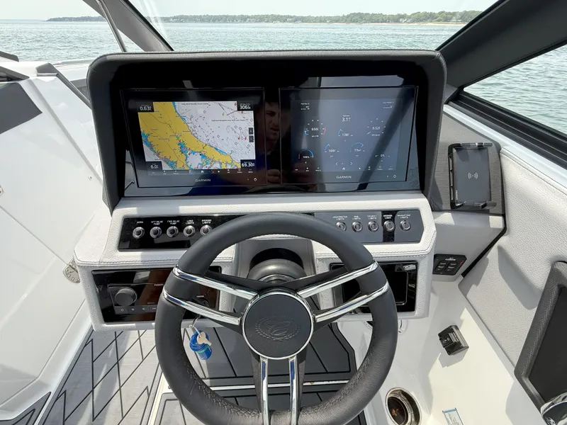 Slide: The Image of 2024 Cobalt R8 Outboard dashboard with navigation screens and steering wheel on a boat. - 22
