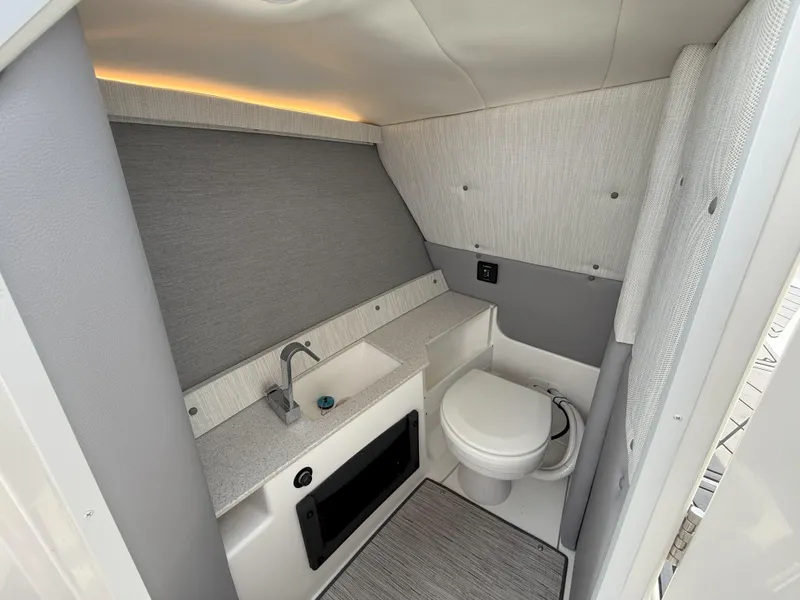 Slide: The Image of 2024 Cobalt R8 Outboard boat interior bathroom with modern sink and toilet. - 25