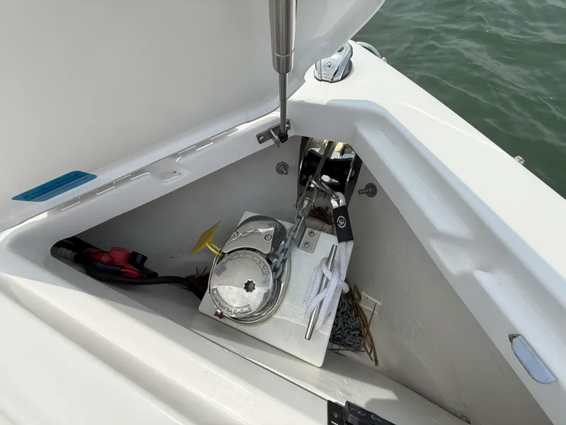 Slide: The Image of 2024 Cobalt R8 Outboard anchor compartment with winch and rope, open hatch, on water. - 28