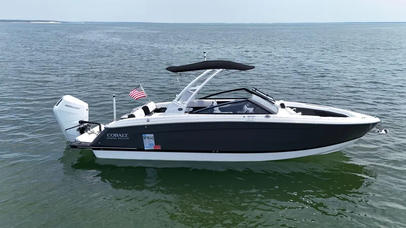 Slide: The Image of 2024 Cobalt R8 Outboard boat on calm water, featuring sleek design and American flag. - 6
