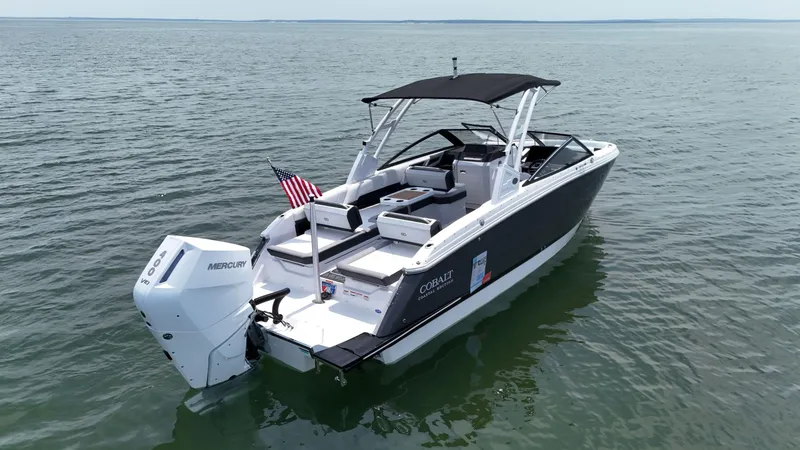 Slide: The Image of 2024 Cobalt R8 Outboard boat on calm water, featuring sleek design and Mercury engine. - 8