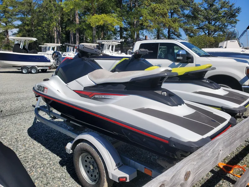 Slide: The Image of 2019 Yamaha WaveRunner EX Deluxe jet skis on a trailer in a parking lot. - 2
