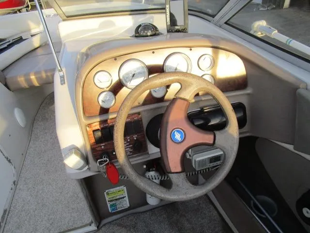 Slide: The Image of 1998 Four Winns 240 Horizon boat dashboard with steering wheel and gauges. - 10