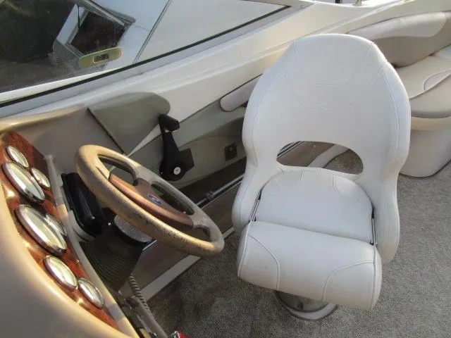 Slide: The Image of 1998 Four Winns 240 Horizon boat cockpit with steering wheel and captain's chair. - 9