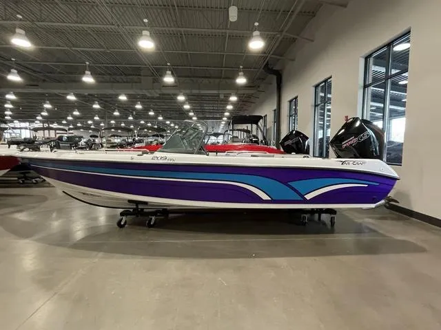 Slide: The Image of 2023 Yar-Craft 209 TFX boat in showroom, featuring a sleek purple and blue design. - 0