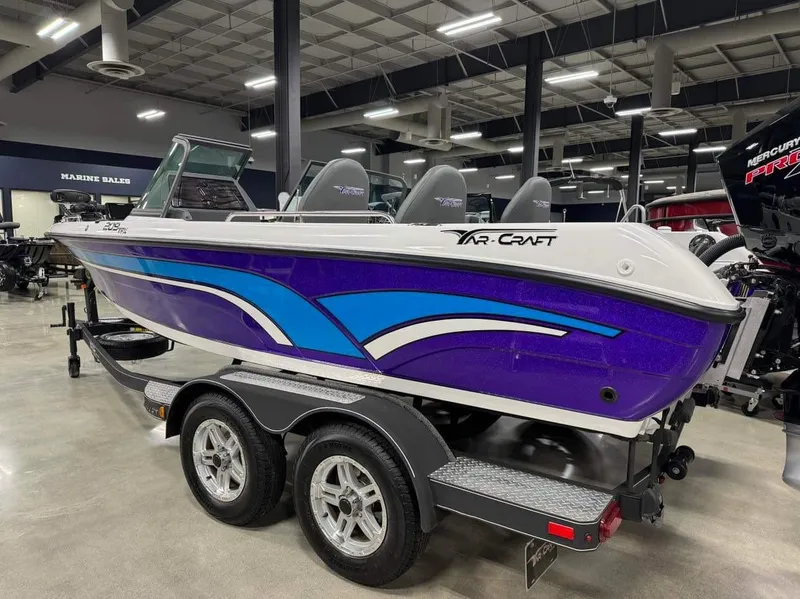 Slide: The Image of 2023 Yar-Craft 209 TFX boat with vibrant purple and blue design on a trailer. - 2