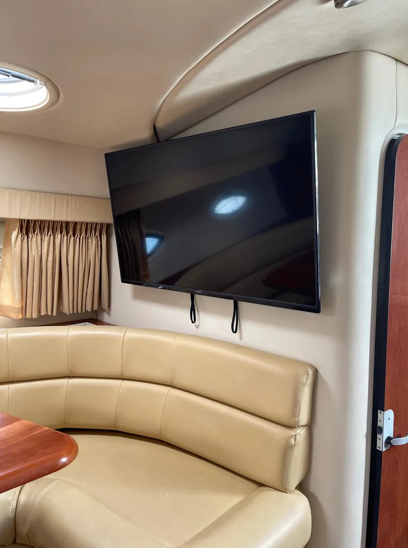 Slide: The Image of Interior of 2006 Monterey 322 Cruiser with mounted TV and beige leather seating. - 24