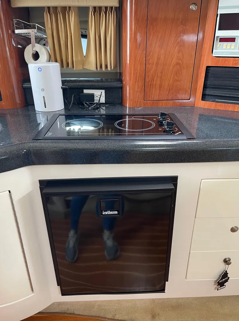 Slide: The Image of 2006 Monterey 322 Cruiser kitchen with stove, mini fridge, and wooden cabinets. - 26