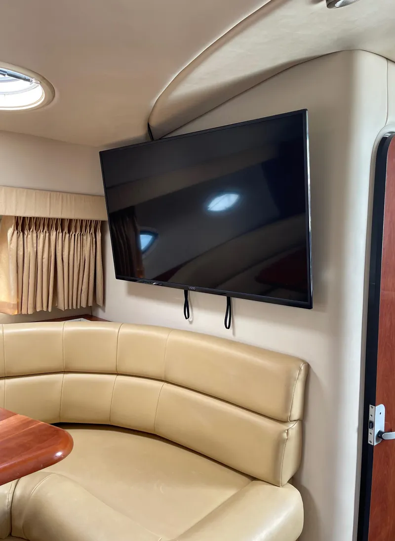 Slide: The Image of Interior of a 2006 Monterey 322 Cruiser with a mounted flat-screen TV and beige leather seating. - 7