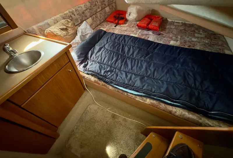 Slide: The Image of 1998 Bayliner 3388 Command Bridge Motoryacht cabin with bed, sink, and life jackets. - 13