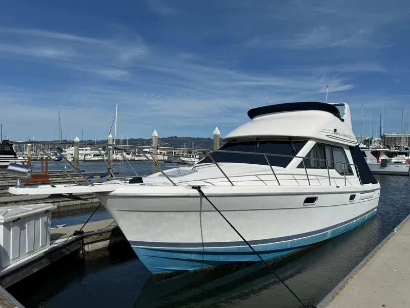 Slide: The Image of 1998 Bayliner 3388 Command Bridge Motoryacht docked at marina under clear sky. - 4