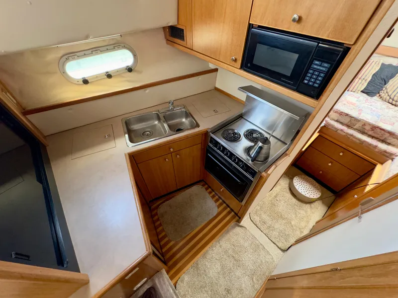 Slide: The Image of 1998 Bayliner 3388 Command Bridge Motoryacht kitchen with stove, microwave, and sink. - 7