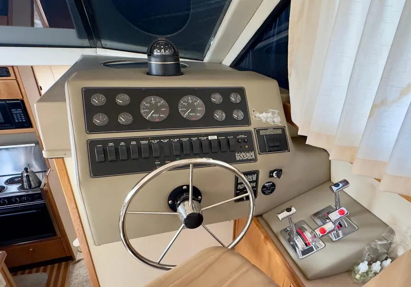 Slide: The Image of 1998 Bayliner 3388 Command Bridge Motoryacht helm with steering wheel and control panel. - 8