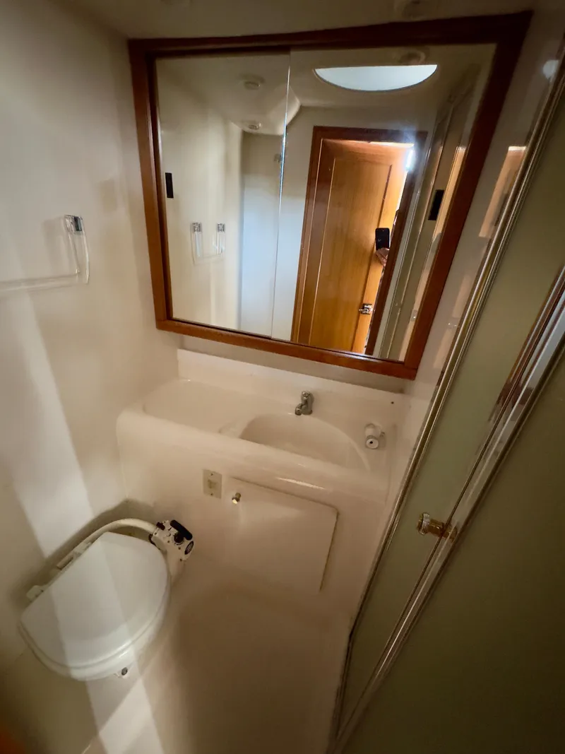 Slide: The Image of 1998 Bayliner 3388 yacht bathroom with sink, mirror, and toilet. - 9