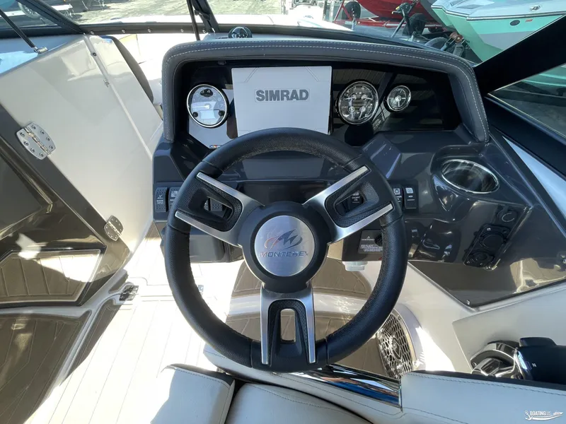 Slide: The Image of 2024 Monterey M4 boat dashboard with steering wheel and Simrad display. - 6