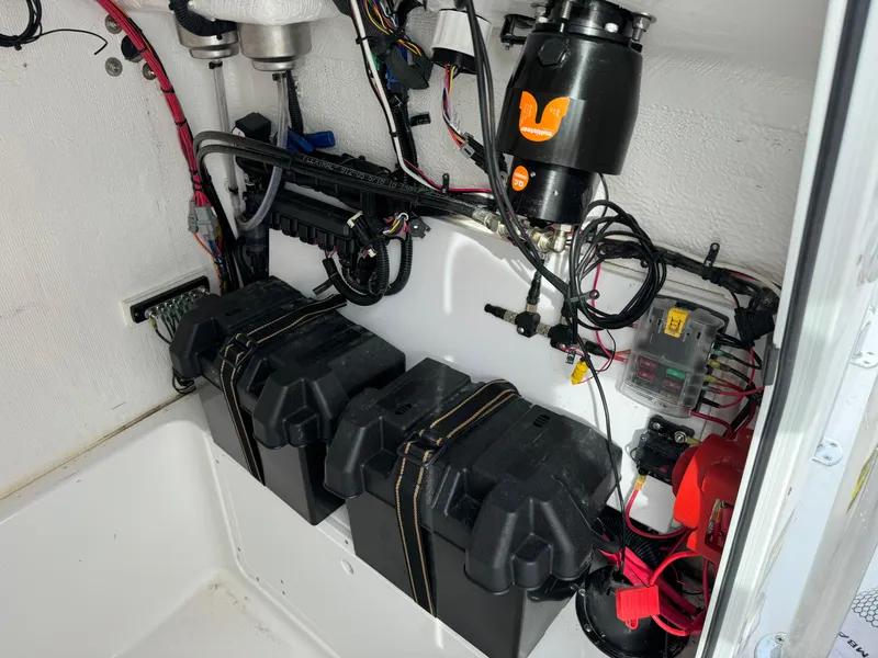Slide: The Image of 2023 Aquasport 22 CC boat battery compartment with wiring and components. - 10
