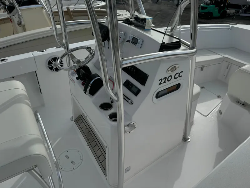 Slide: The Image of 2023 Aquasport 22 CC center console boat interior with steering wheel and controls. - 2