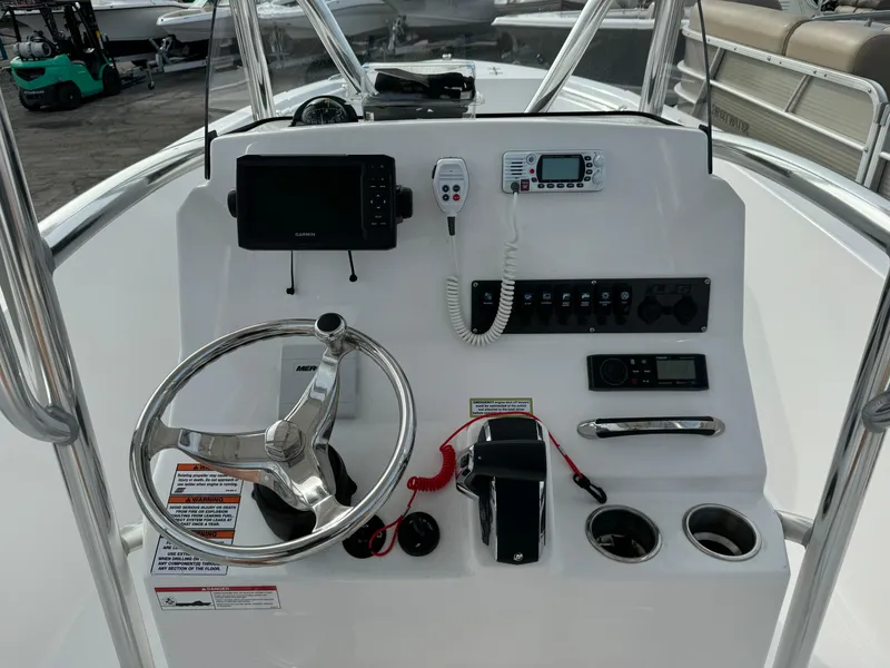 Slide: The Image of 2023 Aquasport 22 CC boat console with steering wheel, electronics, and controls. - 5