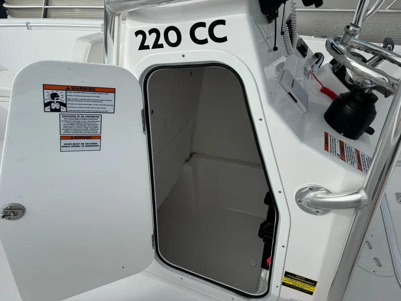 Slide: The Image of 2023 Aquasport 22 CC boat with open storage compartment. - 6