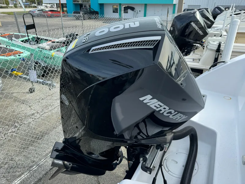 Slide: The Image of 2023 Aquasport 22 CC with Mercury outboard engine in a marina. - 8