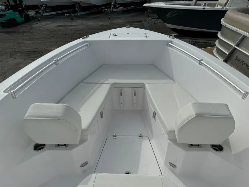 Slide: The Image of 2023 Aquasport 22 CC boat with white seating and storage compartments. - 9
