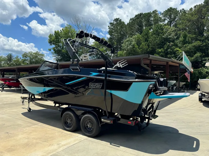 Slide: The Image of 2023 Heyday H-22 boat on trailer, black and blue, parked outdoors. - 1
