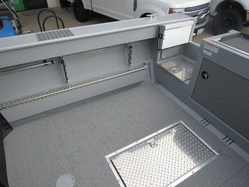 Slide: The Image of 2024 Hewescraft 220 OCEAN PRO HT FC boat interior with storage compartments and diamond plate flooring. - 10