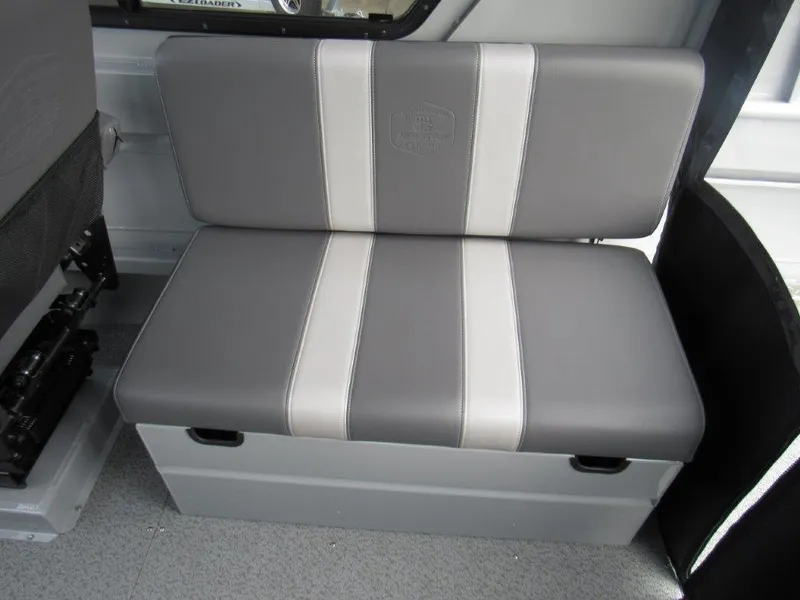 Slide: The Image of 2024 Hewescraft 220 OCEAN PRO HT FC interior seating, gray and white cushioned bench. - 15