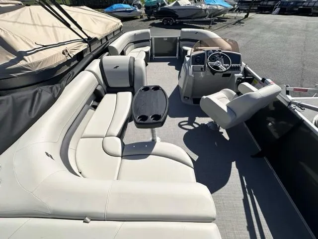 Slide: The Image of 2024 Starcraft EX 20 C pontoon boat interior with plush seating and captain's console. - 2