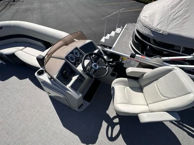 Slide: The Image of 2024 Starcraft EX 20 C pontoon boat interior with captain's chair and control console. - 3